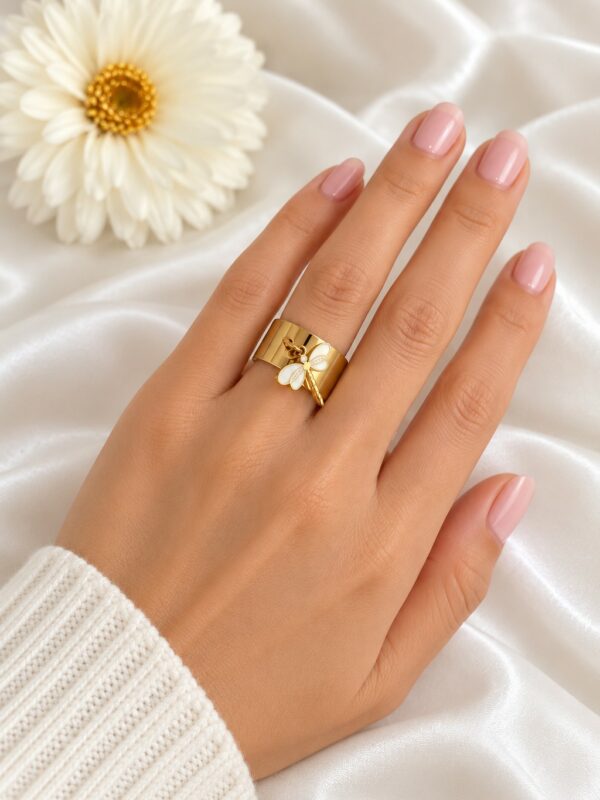 Bague Libellule dorée ajustable en acier inoxydable portée au doigt.
