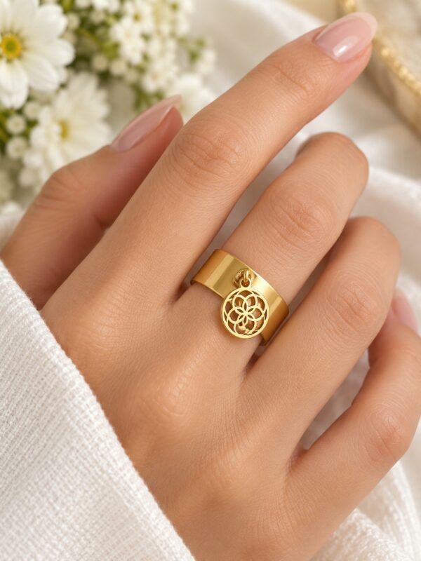 Bague Aëlis dorée ajustable en acier inoxydable portée au doigt.