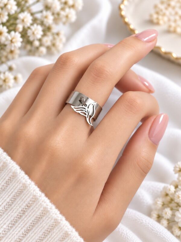 Bague Jena oiseau argentée ajustable en acier inoxydable portée au doigt.