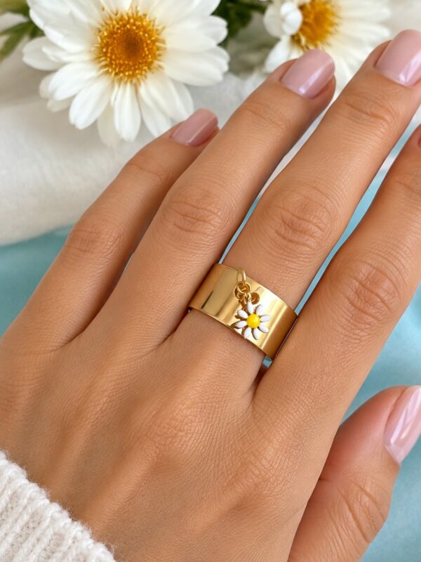 Bague Marguerite dorée ajustable en acier inoxydable portée au doigt.