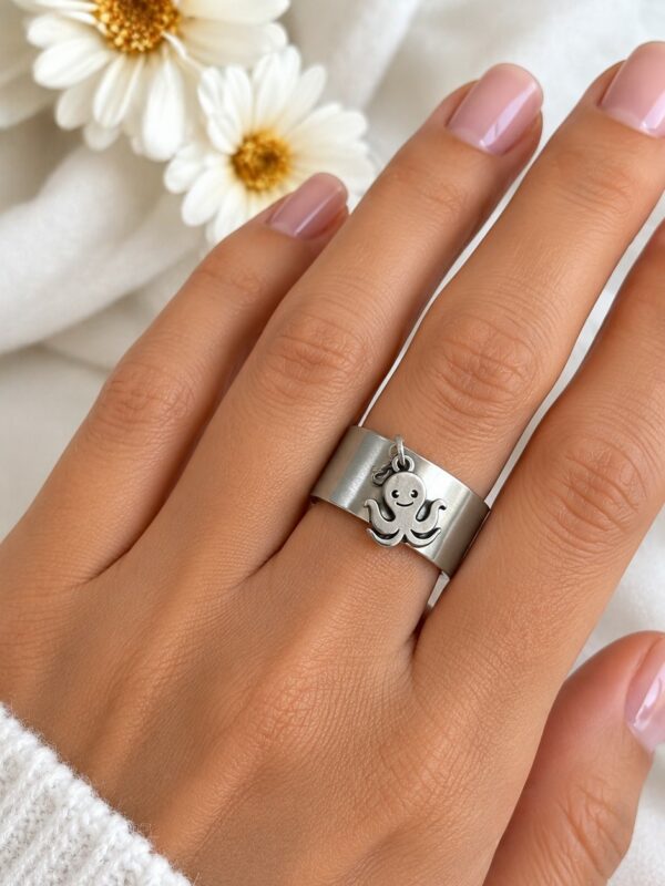 Bague Poulpe argentée ajustable en acier inoxydable portée au doigt.