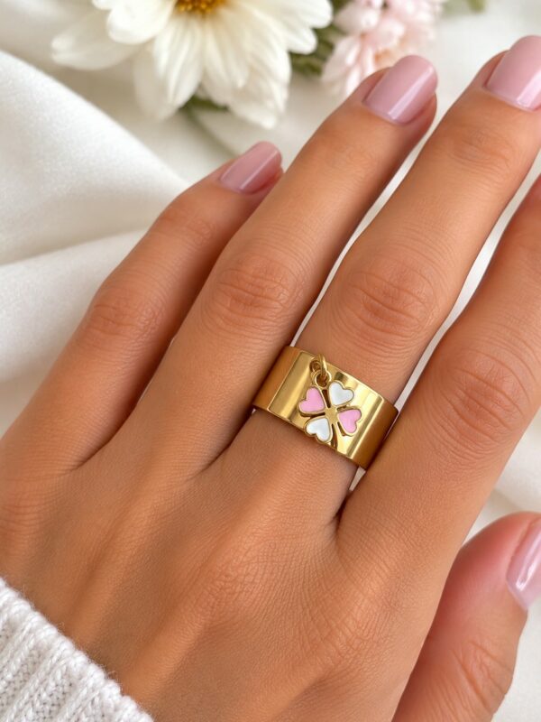Bague Roxane trèfle dorée ajustable en acier inoxydable portée au doigt.