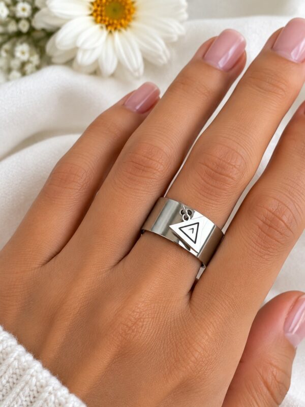 Bague Tara triangle argenté ajustable en acier inoxydable portée au doigt.