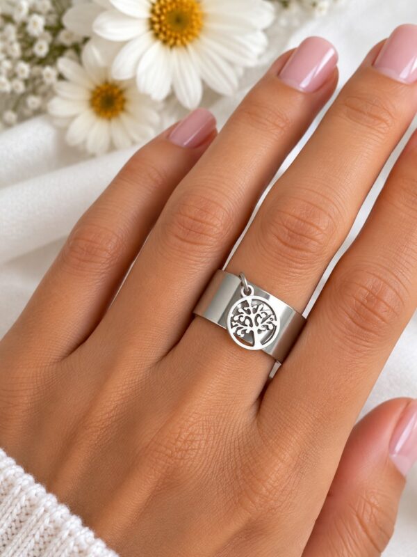 Bague Théa Argentée arbre de vie ajustable en acier inoxydable portée au doigt.