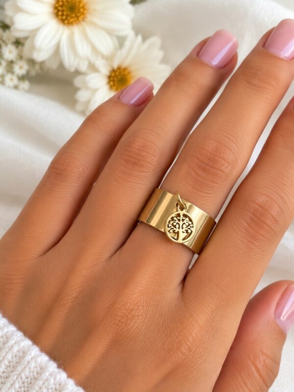 Bague Théa Dorée arbre de vie ajustable en acier inoxydable portée au doigt.