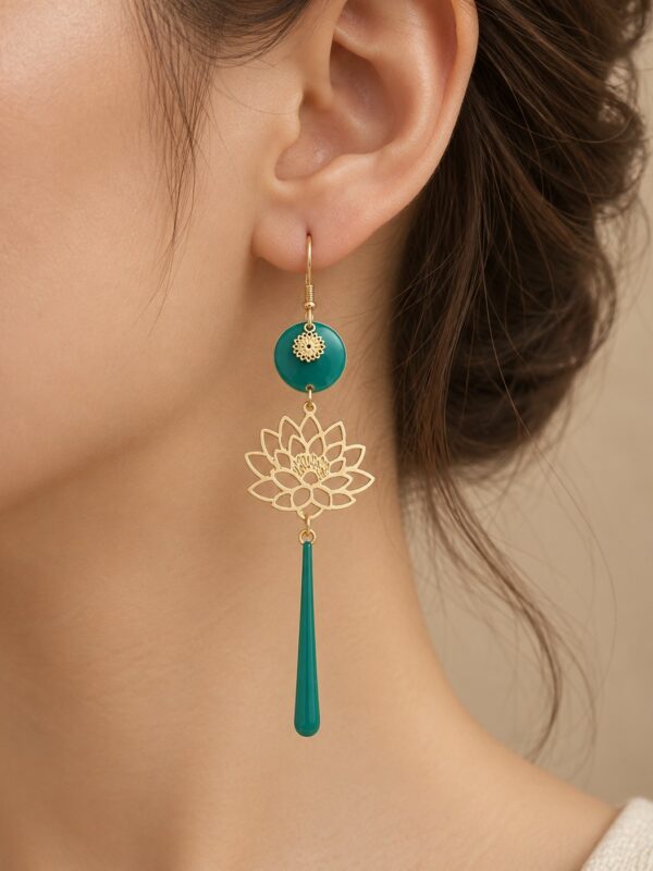Boucles d'oreilles Elise dorées et vert jade motif lotus portées sur une oreille.