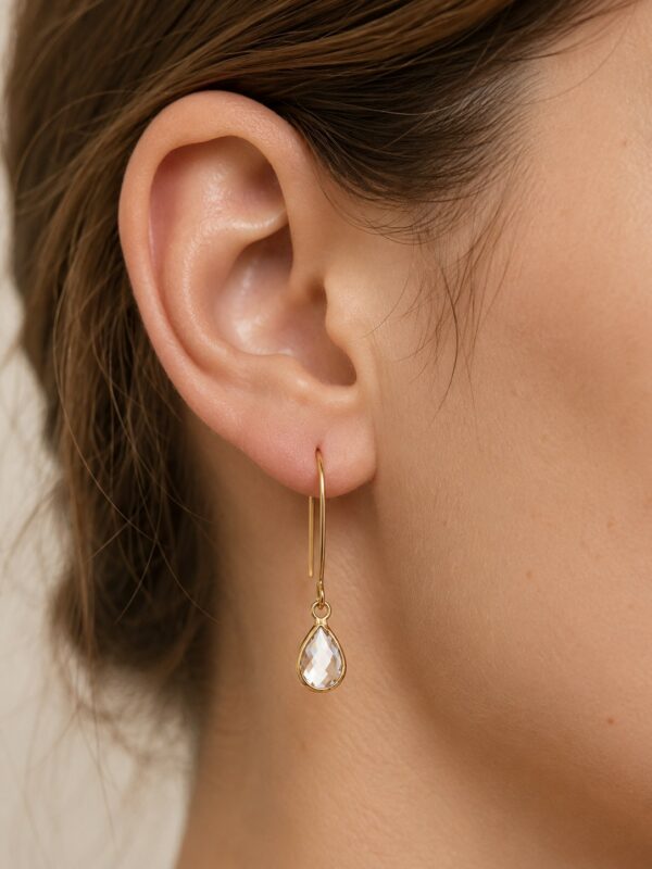 Boucles d'oreilles dorées en acier inoxydable avec perle en verre portées