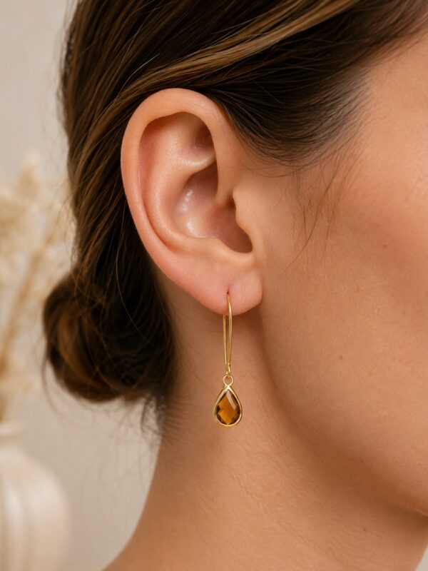 Boucles d'oreilles dorées avec perle en verre ambrée portées