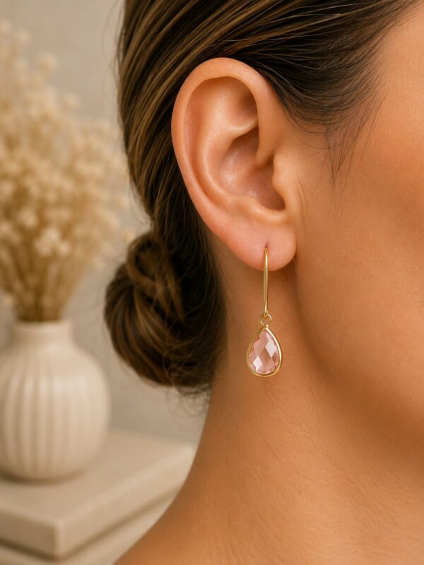 Boucles d'oreilles goutte rose en acier inoxydable Lili Rose portées sur une oreille.