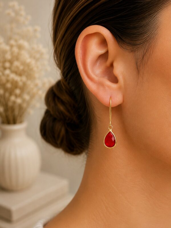 Boucles d'oreilles dorées perle en verre rouge Lili portées sur une oreille