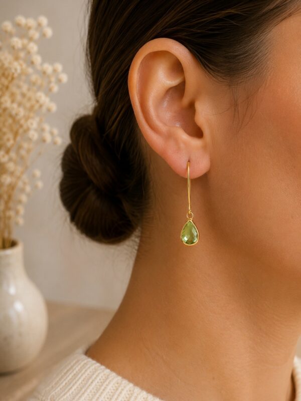 Boucles d'oreilles dorées perle en verre verte Lili portées sur une oreille.