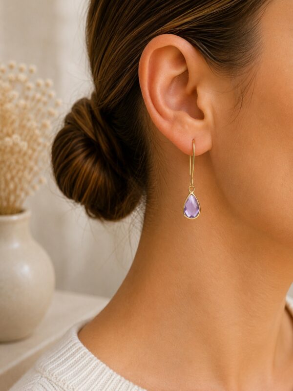 Boucles d'oreilles dorées perle en verre violette Lili portées sur une oreille.