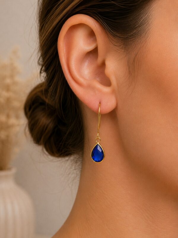 Boucles d'oreilles dorées avec perle en verre bleu roi.