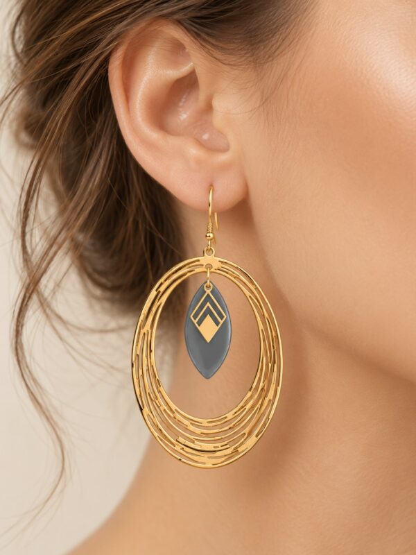 Boucles d'oreilles Maïlys dorées et grises portées sur une oreille.