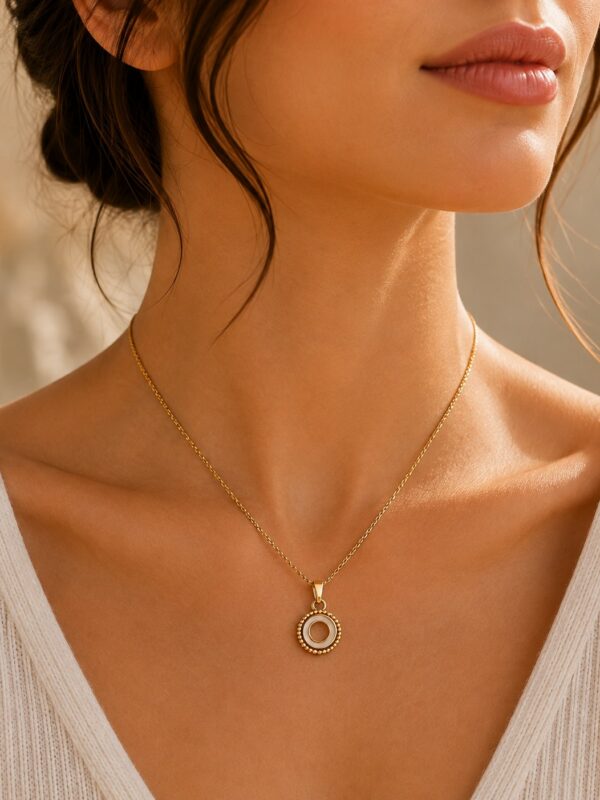 Collier doré rond ajouré blanc nacré Juliette porté au cou.