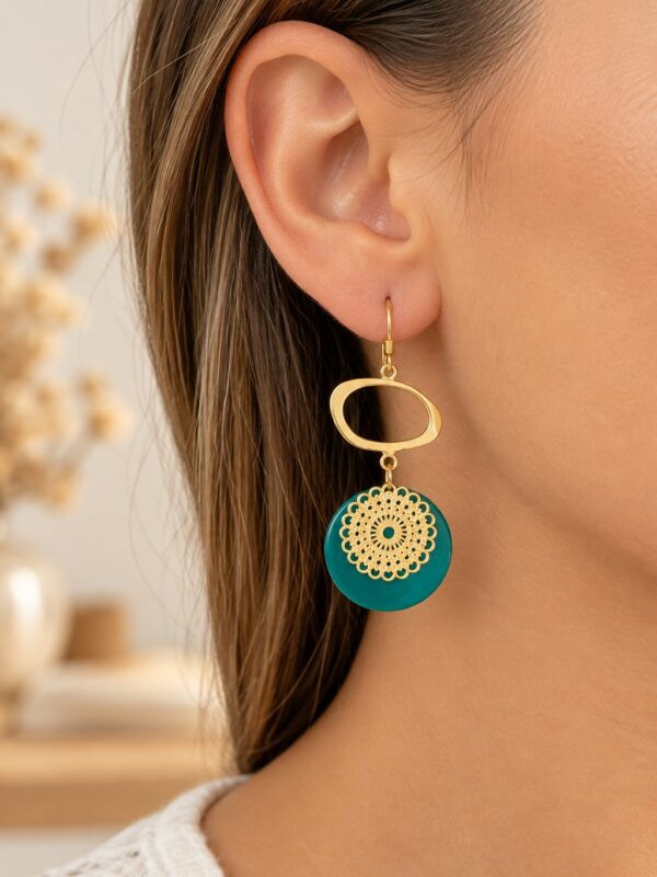 Boucles d'oreilles Olivia dorées et vert jade portées sur une oreille.