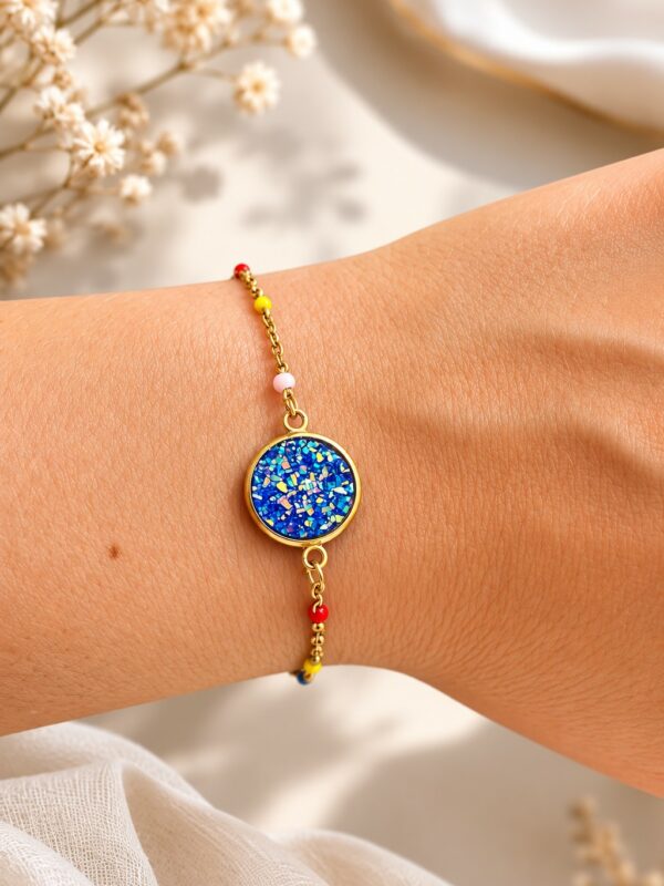 Bracelet doré bleu en acier inoxydable porté au poignet avec perles multicolores - bracelet Alix