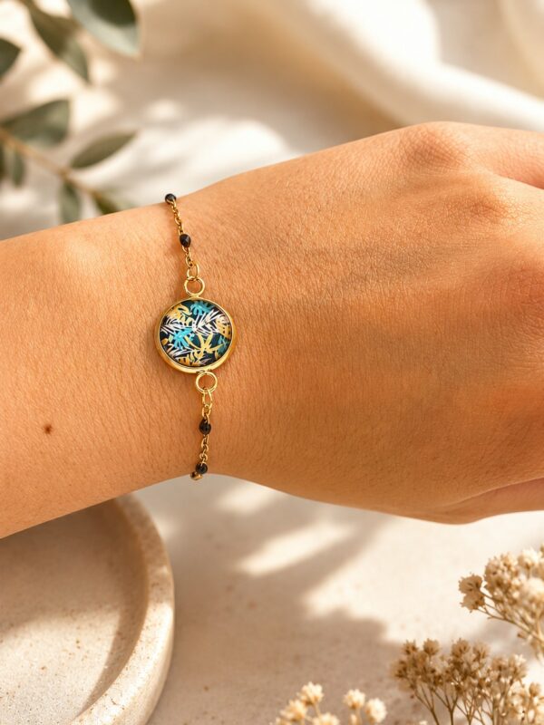 Bracelet doré à motif feuilles en acier inoxydable porté au poignet