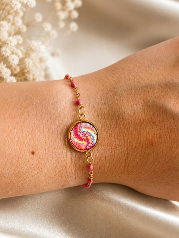Bracelet doré rose en acier inoxydable avec médaillon spiralé porté au poignet