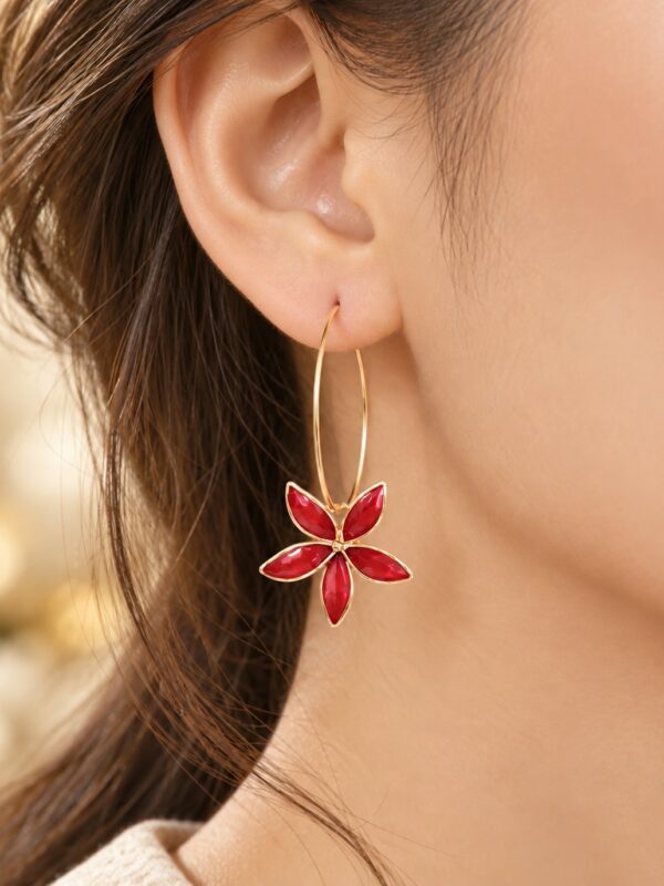 Créoles Alice dorées et rouges motif fleur portées sur une oreille.
