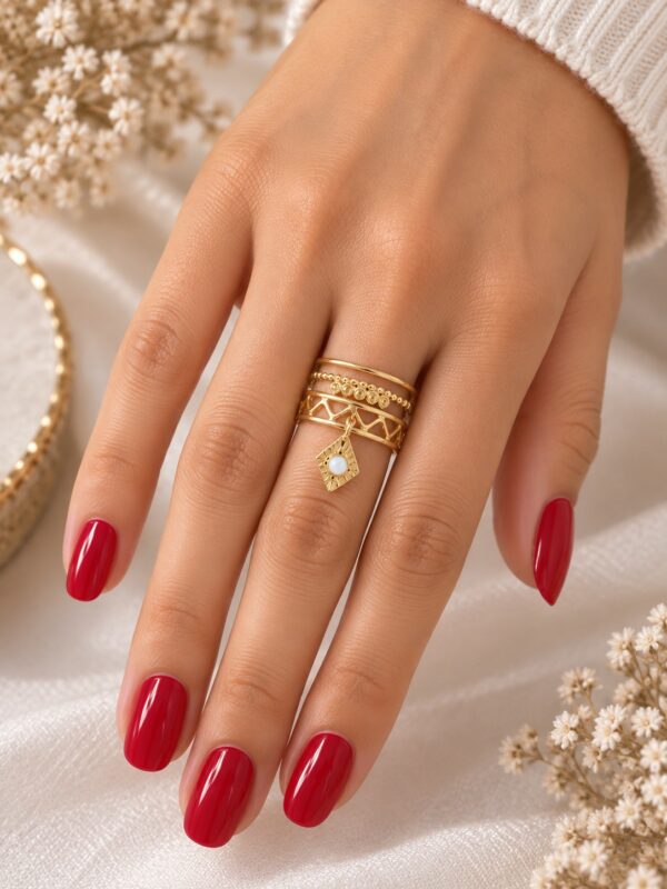 Bague Irina Blanche dorée ajustable avec losange blanc nacré portée au doigt.