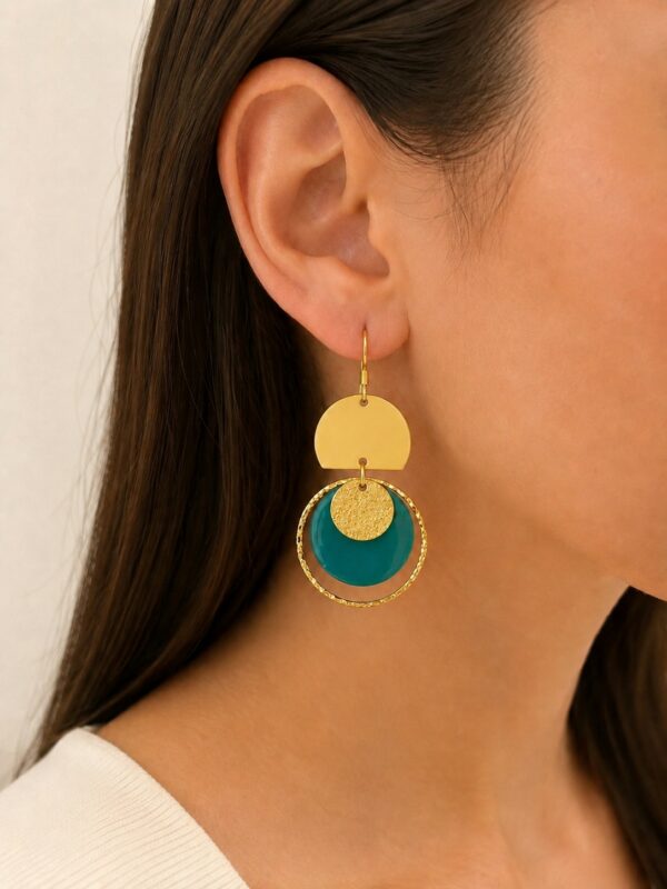 Boucles d'oreilles Jade pendantes dorées et vert jade portées sur une oreille.
