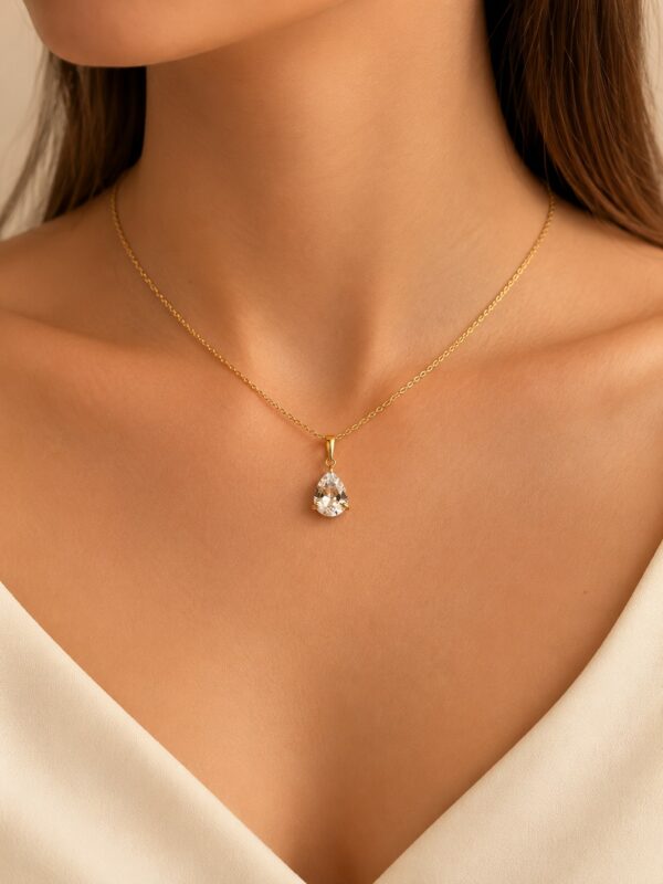 Collier doré goutte zircone en acier inoxydable porté au cou.