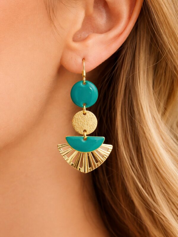 Boucles d'oreilles Gaby pendantes dorées et vert jade portées sur une oreille.