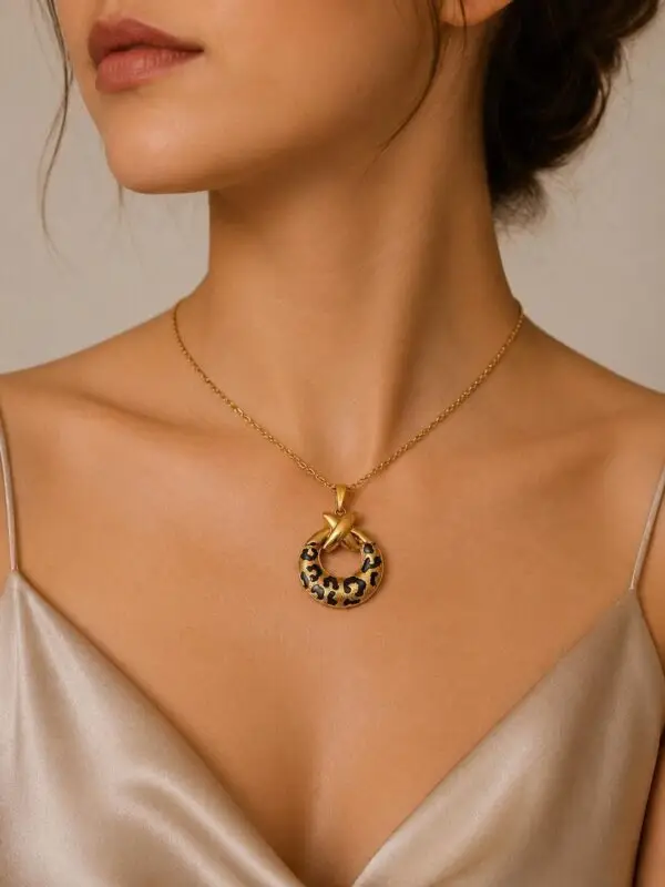 Collier doré motif léopard noir en acier inoxydable Leonne porté au cou.