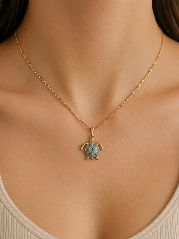 Collier doré tortue bleu en acier inoxydable porté au cou.